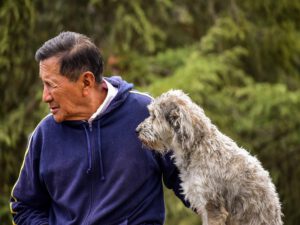 Älterer Mann mit Hund in der Natur