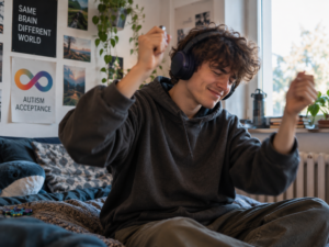 Junger autistischer Mann mit ADHS beim Stimming mit rhythmischen Handbewegungen und Kopfhörern